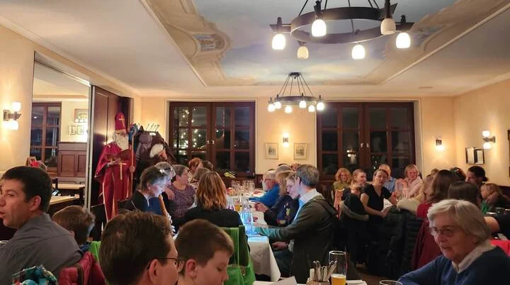 Weihnachtsfeier des DAV Markt Schwaben 2025 | © DAV Markt Schwaben Festlich geschmückter Raum mit geselligen Gästen bei der Weihnachtsfeier des DAV Markt Schwaben 2025. Warme Beleuchtung, fröhliche Atmosphäre und traditionelle Weihnachtsfiguren im Hintergrund | © DAV Markt Schwaben