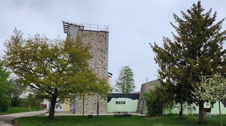 DAV Kletterzentrum Markt Schwaben | © DAV Markt Schwaben Das Kletterzentrum der DAV-Sektion Markt Schwaben – eine hohe Kletterwand mit bunten Griffen, umgeben von Bäumen und Natur, bietet Herausforderungen für alle Kletterbegeisterten. | © DAV Markt Schwaben